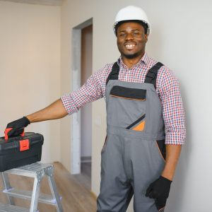 Young cheerful African American repairman.